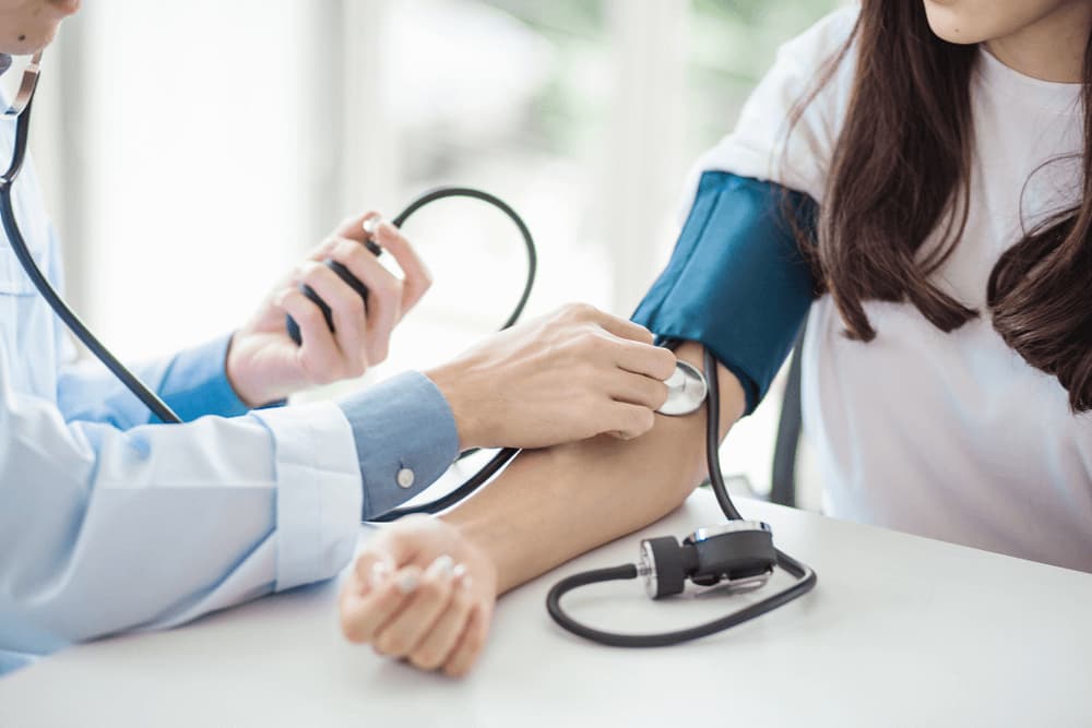 Medical Doctor Checking Womans Blood Pressure